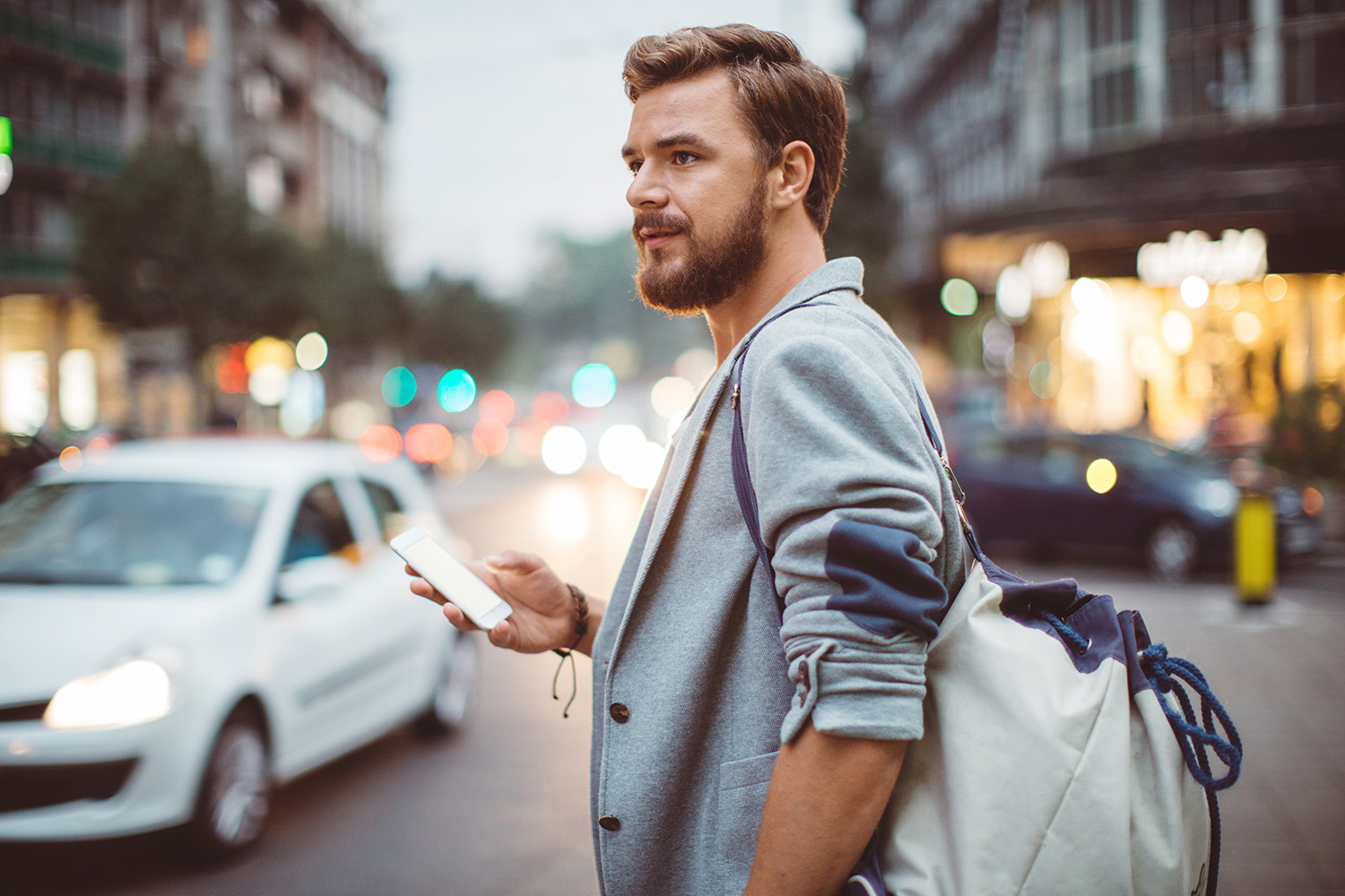 Man standing on an city street waiting for a ride share pickup